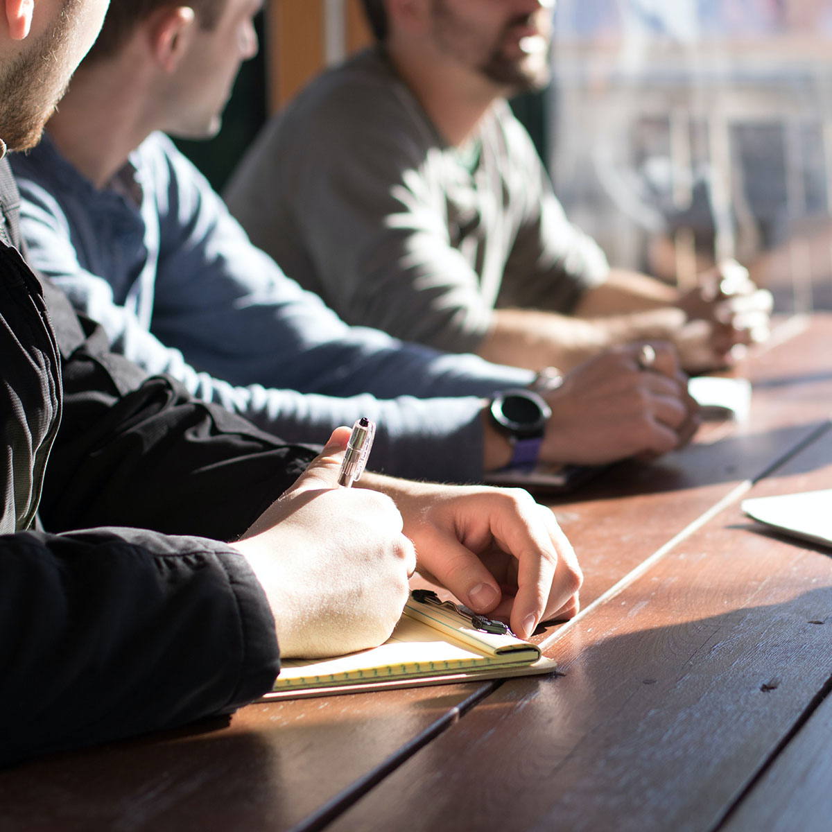 A group of people collaborate at work around a desk