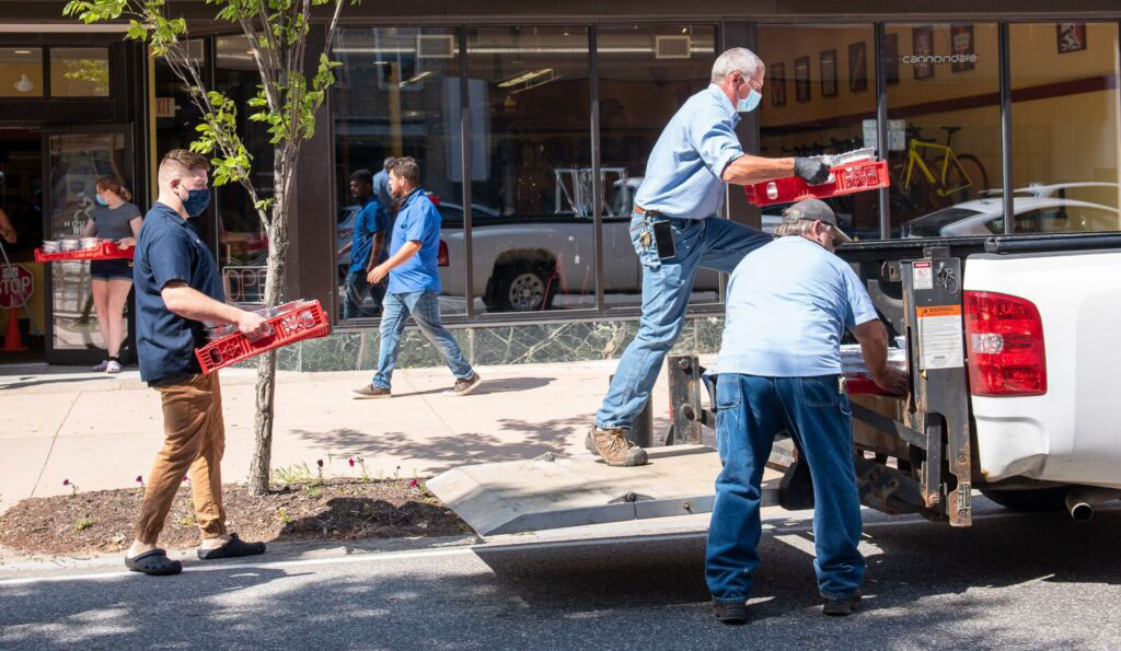 John Grandmaison, right, and Mike Mills from Lewiston Housing load up one of their trucks